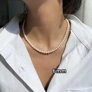Detailed view of 6mm pearl necklace on model showing 14K gold plated pendant luster