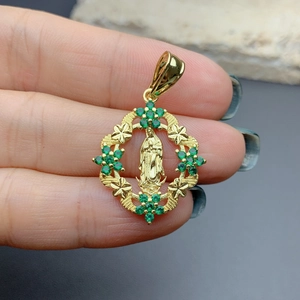 Vintage gold Guadalupe pendant with green zircon inlay shown held by fingers