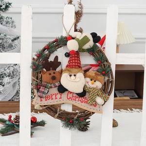 Christmas rattan wreath with Santa, reindeer and snowman dolls on white wooden fence