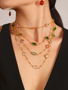 Gros plan du collier doré multi-rangs orné de pierres en verre colorées et de cristaux