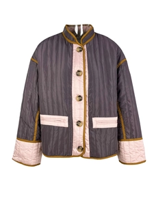 Detail view of quilted color-block jacket with amber buttons and pink stand-up collar