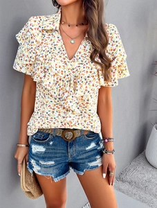 Close-up of floral v-neck shirt featuring elegant ruffle layers and yellow flower pattern