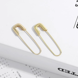 Detailed view of elegant gold paperclip earrings on a minimalist white background