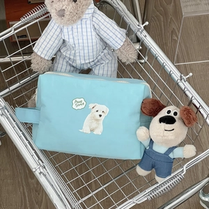 Detail of blue dog pattern makeup bag with handle and zipper inside a shopping cart