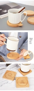 Detailed view of laser-engraved solid wood coasters with mugs on a modern table