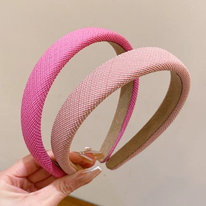 Striped sponge headbands in pink and peach colors with woven texture and non-slip lining