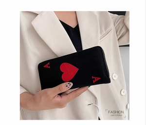 Detail of canvas long wallet featuring red Ace of Hearts print and golden zipper