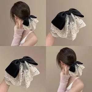 Detalle de diadema con lazo de satén negro y bordado de encaje beige elegante
