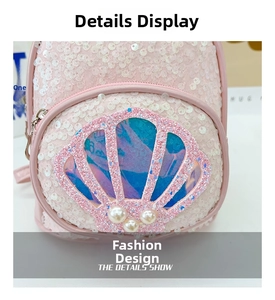 Detailed macro view of pink sequin backpack featuring shell ornament and pearl accents
