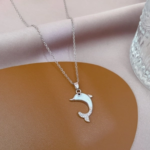 Detail of silver dolphin necklace with white shell inlay and sparkling zircons