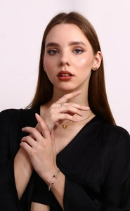 Close-up of elegant gold ribbon bow jewelry set including necklace and stud earrings