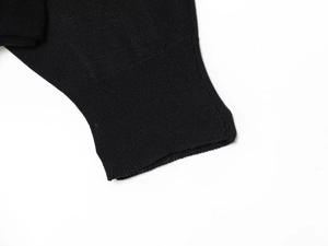 Close-up of fine ribbed cuff detail on black batwing sleeve knit sweater top