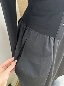 Detailed view of functional side pocket on black mixed-media knit and woven dress