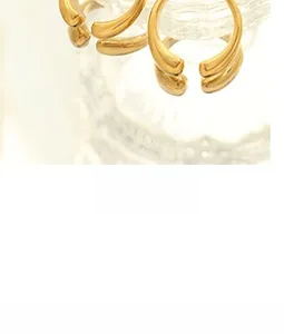 Detailed close-up of thick gold-plated C-shaped earrings with a high-polished finish