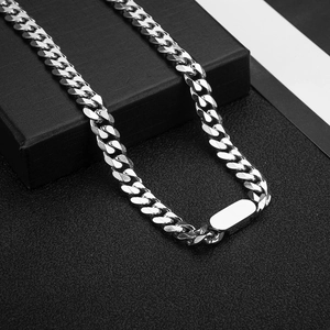 Detail of silver titanium steel Cuban chain with flat rectangular clasp on black box