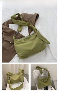 Detail view of large green canvas tote bag with knot strap and silver chain accent