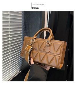 Detail of brown rectangular handbag with geometric triangle quilting and wide shoulder strap