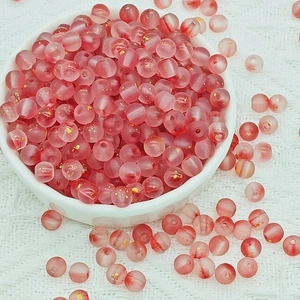 Macro shot of 8mm pink and red frosted glass beads with gold foil for DIY jewelry making