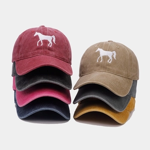 Group shot of washed cotton baseball caps with horse embroidery in seven vintage colors