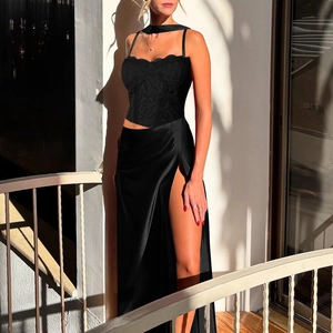Detailed view of the black lace corset top and high-slit satin skirt on a balcony