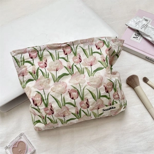Vue à plat de la trousse cosmétique matelassée à tulipes avec accessoires de beauté