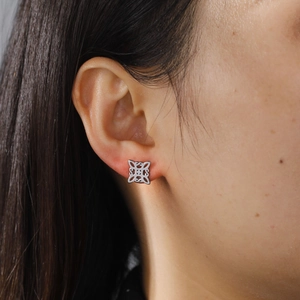Silver cut-out geometric Celtic knot stud earring worn by a model in a side view