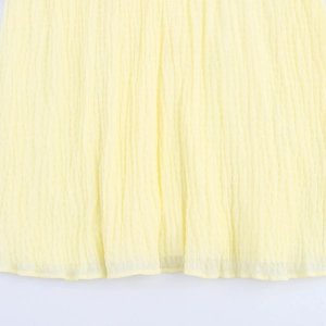 Close-up of pale yellow textured seersucker fabric with vertical crinkle patterns