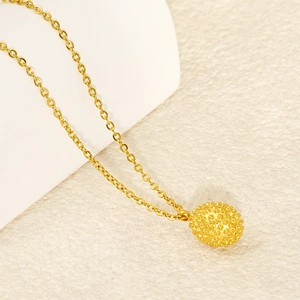 Detailed close-up of a golden durian fruit pendant with textured spikes on a fine chain