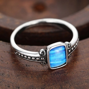 Detailed view of bohemian vintage ring with blue rectangle stone and silver beadwork