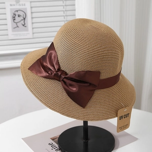 Détail d'un chapeau de soleil anti-UV avec tissage fin et élégant nœud en satin marron