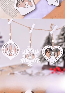 Detail of laser-cut wooden Christmas ornaments with snowflake and cabin designs
