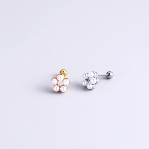 Detailed macro view of gold and silver flower stud earrings with five white pearls