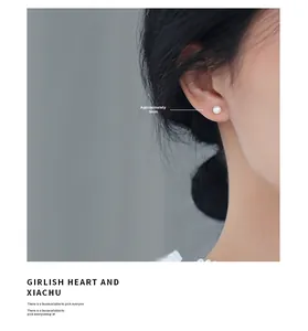 Detail of 5mm white round pearl stud earring with 925 silver needle on model ear