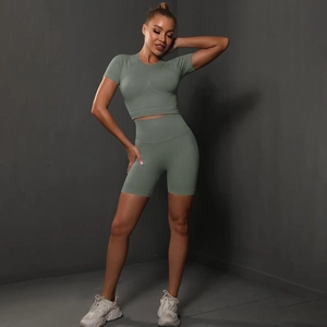 Detailed texture of seamless green yoga set featuring high-waisted shorts and crop top