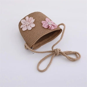 Détail du sac bandoulière en paille pour enfant avec fleurs en dentelle rose et sangle