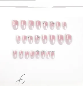 Detail view of pink gradient press-on nails with 3D rhinestones and flower texture