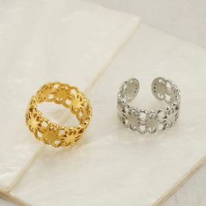 Adjustable hollow floral titanium steel rings in gold and silver on white shell surface