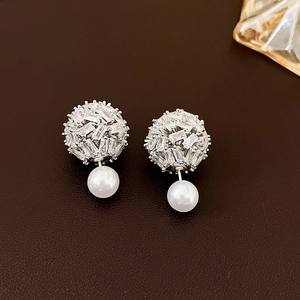 Detail shot of silver earrings with rectangular zircon spheres and round white pearls