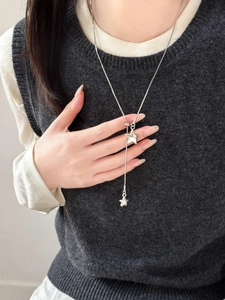 Silver star pendant necklace styled on a grey sweater showing its adjustable Y-shape fit