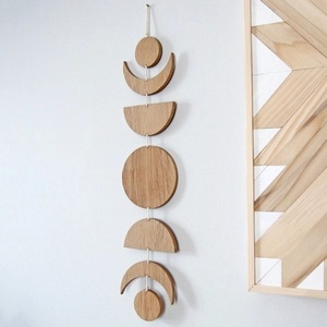 Vertical view of decorative wooden moon phase wall hanging with seven natural wood pieces