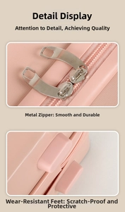 Detail of pink 14-inch mini suitcase showing smooth metal zippers and wear-resistant feet