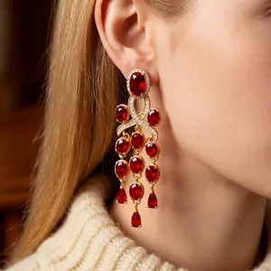 Vintage gold drop earrings with ruby red gemstones and zircon tassels on model