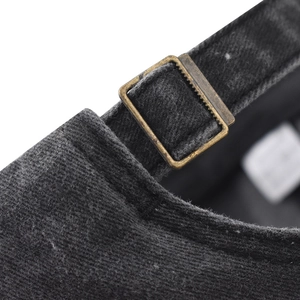Gros plan détaillé de la boucle réglable en métal bronze sur une casquette en coton délavé
