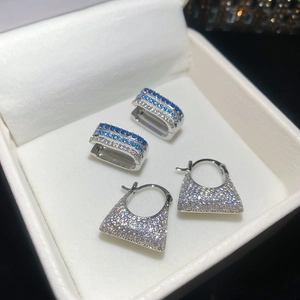 Macro detail of silver hoop earrings with triple-row blue and clear zircon stones