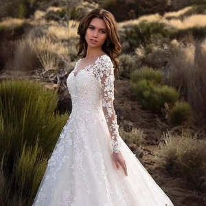 Elegant white lace long sleeve A-line wedding dress with floral appliques outdoors