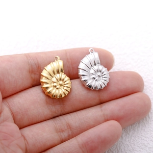 18K gold and silver conch shell pendants in stainless steel held in palm for DIY jewelry