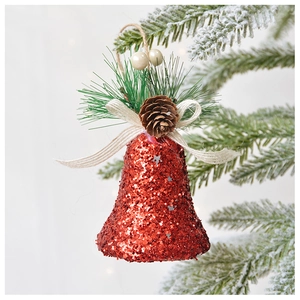 Détail d'une cloche rouge pailletée avec pommes de pin et baies sur une branche de sapin