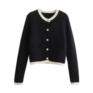 Close-up of contrast trim detail and golden crest buttons on black knit cardigan