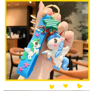 Detail of white 3D unicorn keychain with blue silicone strap and green star pendant