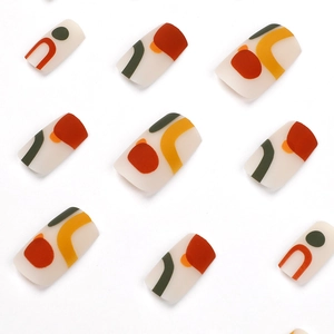 Abstract geometric press-on nails in matte off-white with red and olive green patterns